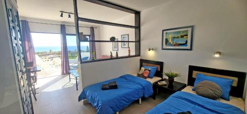 a bedroom with two beds and a view of the ocean at Ferienwohnung Aurora in Giniginámar