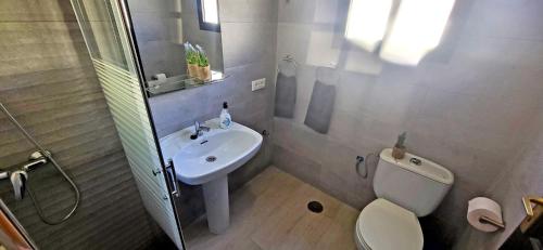 a bathroom with a toilet and a sink at Ferienwohnung Aurora in Giniginámar