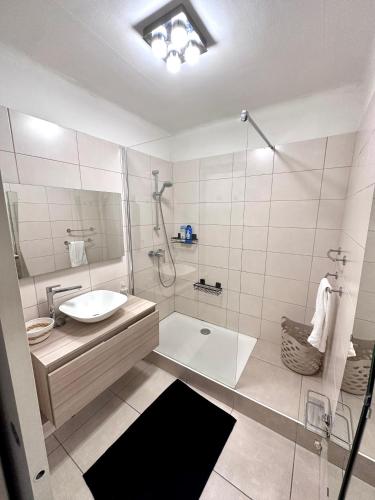 une salle de bain blanche avec un lavabo et une douche dans l'établissement GRAND T2 PROCHE VELODROME ET MER, à Marseille