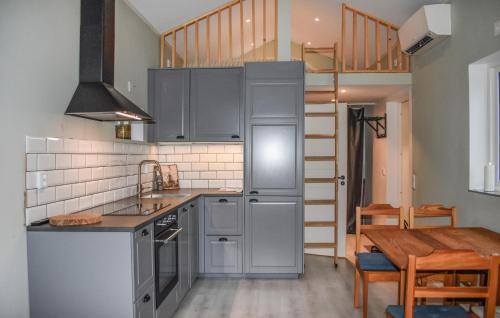 a kitchen with gray cabinets and a wooden table at Gorgeous Home In Sturkö With Kitchen in Sturkö