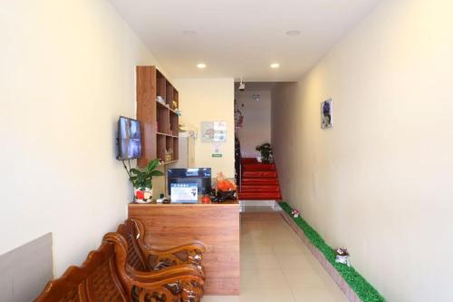 a hallway with two chairs and a television and stairs at Xinming Fashion Hotel in Yanji