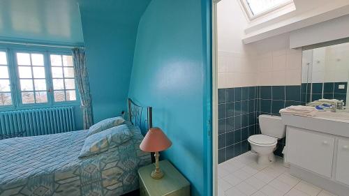 a blue bedroom with a bed and a bathroom at Le Beauvais, son gîte, ses chambres en Bourgogne in Saint-Saulge