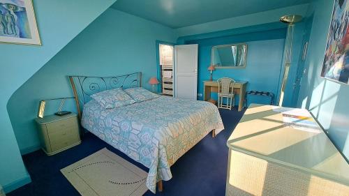 a blue bedroom with a bed and a table at Le Beauvais, son gîte, ses chambres en Bourgogne in Saint-Saulge