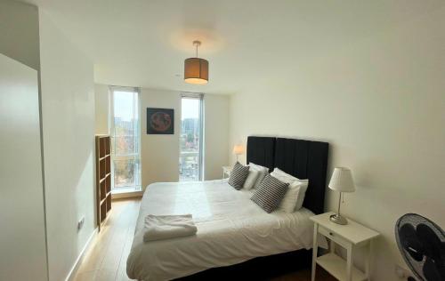 een slaapkamer met een groot bed met witte lakens en kussens bij Bracknell Stylish Two Bedroom Apartment in Bracknell