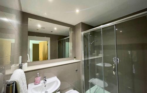 een badkamer met een glazen douche en een wastafel bij Bracknell Stylish Two Bedroom Apartment in Bracknell