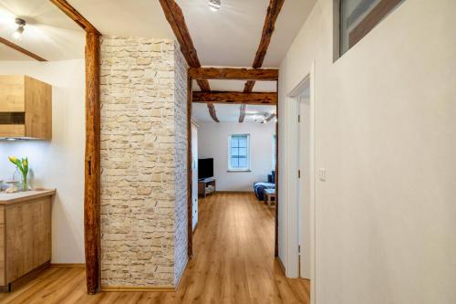 a room with a stone wall and a hallway with a kitchen at Ferienwohnung Haseltal in Rotenburg an der Fulda