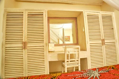 a chair sitting in a room with a mirror at Lions' Luxury Eco Resort & Spa in Malindi