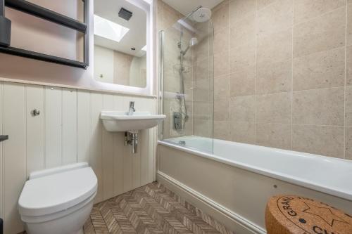 een badkamer met een toilet, een wastafel en een bad bij Castle House 4 in Wells next the Sea