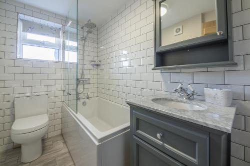 een badkamer met een wastafel, een toilet en een bad bij Burnham Cottage 2 in Wells next the Sea