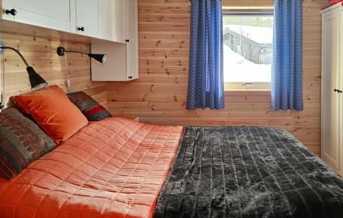 a bedroom with a bed with blue curtains and a window at 3 Bedroom Stunning Home In Rauland in Rauland