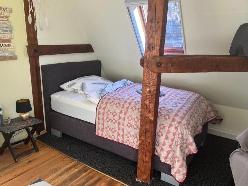 1 dormitorio con litera y escalera de madera en Sandys Cozy Stone Cottage en Maulbronn