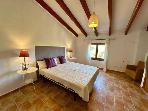 een slaapkamer met een bed, een tafel en een raam bij Finca Es Trenc mit Pool I Whirlpool I BBQ I Klima in Campos