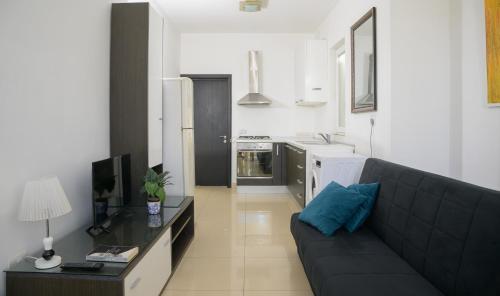 a living room with a couch and a kitchen at Stylish Saint Julians 1 bedroom Penthouse with Terrace in the city centre with Seaview in St. Julianʼs