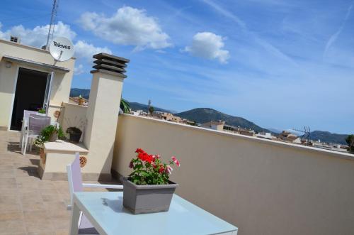 un balcón con una mesa y flores en un edificio en Ideal Property Mallorca - Son Vent Muntanya - 1 en Sa Pobla