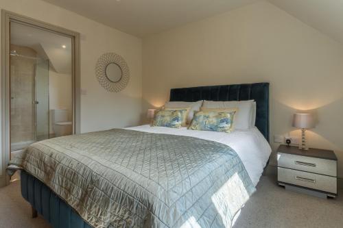 1 dormitorio con 1 cama grande y espejo en Long Meadow 2, en Great Bircham