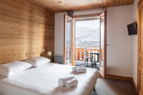 a bedroom with a bed and a large window at Dormio Resort Les Portes du Grand Massif in Flaine