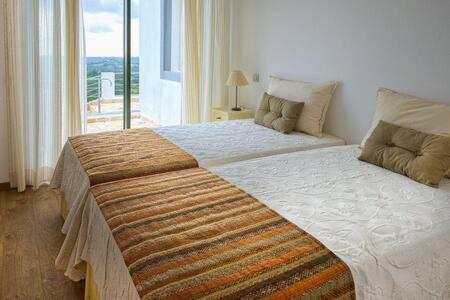 a bedroom with a large bed with a large window at Villa Areias I - Beautiful landscape garden in Estói