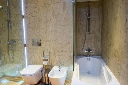 a bathroom with a tub and a toilet and a sink at Villa Areias I - Beautiful landscape garden in Estói
