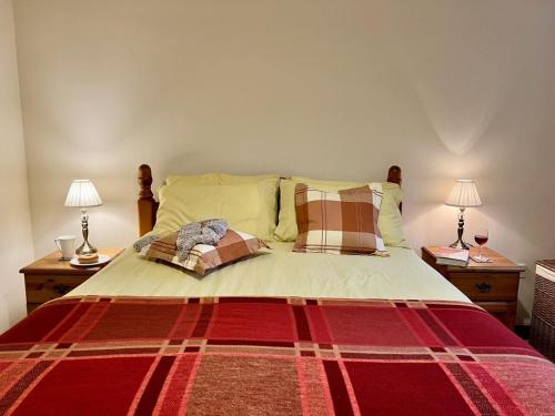 a bedroom with a large bed with two night stands at Caer Dderwen Oak Field family home in Dolgellau in Dolgellau