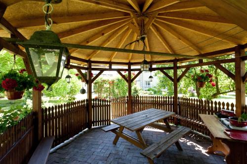 a wooden gazebo with a picnic table and a lamp at Dom Gościnny Basia in Niechorze