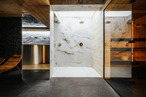 a bathroom with a marble wall at VisitZakopane - Premium Best View&Spa Apartment in Zakopane