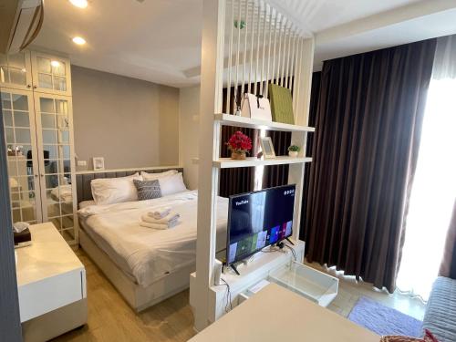 a bedroom with a bed and a tv in a room at The Patio bangsaen miracle Seaview in Ban Bang Saen (1)
