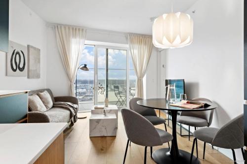 Best view in Denmark from 40th floor في أُرهوس: غرفة معيشة مع أريكة وطاولة وكراسي