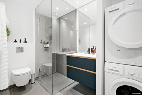 uma casa de banho com um lavatório e uma máquina de lavar roupa em Best view in Denmark from 40th floor em Arhus