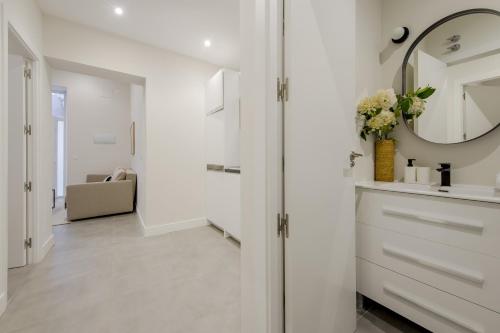 a white bathroom with a mirror and a sink at Modern Design Apt para 7 en Cortes-Museo del Prado in Madrid