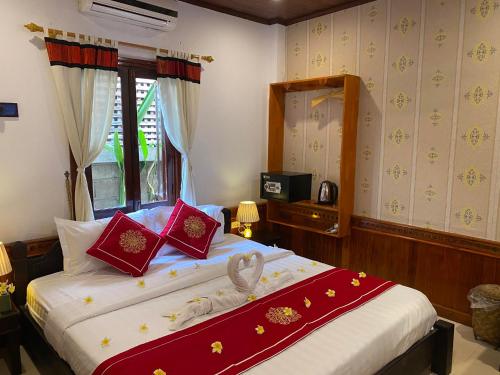 a bedroom with a large bed with red pillows at Golden Lotus Place in Luang Prabang