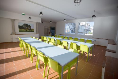 una fila de mesas y sillas amarillas en una habitación en HI Évora – Pousada de Juventude, en Évora