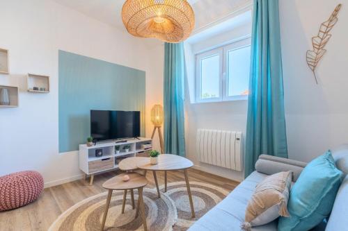 un salon avec un canapé bleu et une télévision dans l'établissement 2 bedroom apartment near tram, CHR + parking, à Roubaix