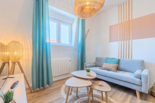 un salon avec un canapé bleu et une table dans l'établissement 2 bedroom apartment near tram, CHR + parking, à Roubaix