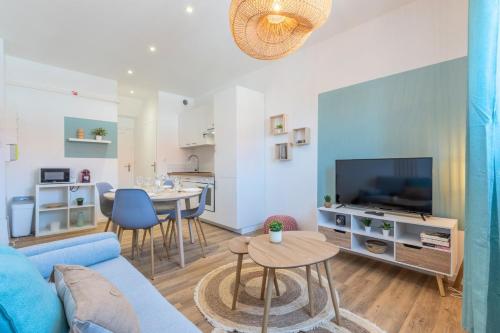 un salon avec un canapé bleu et une table dans l'établissement 2 bedroom apartment near tram, CHR + parking, à Roubaix