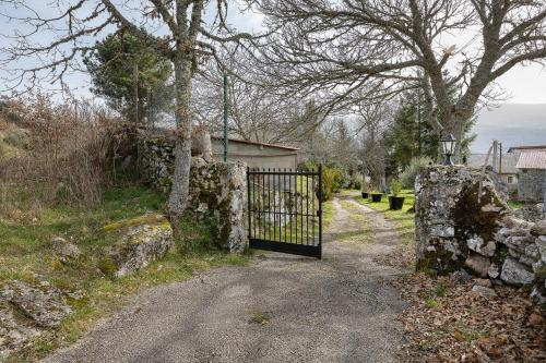 a gate on a road with a stone wall at YourHouse A Casa Dos Cregos in Fonteita