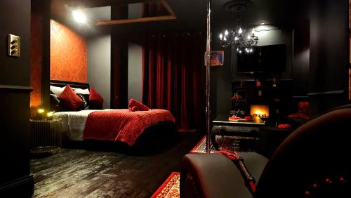 een slaapkamer met een bed met een rode deken bij O' Plaisirs Interdits - Loveroom in Caen