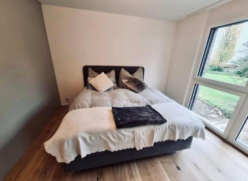 Un dormitorio con una cama con almohadas. en Wohnung am Zürichsee mit Seeblick und Parkplatz, en Horgen
