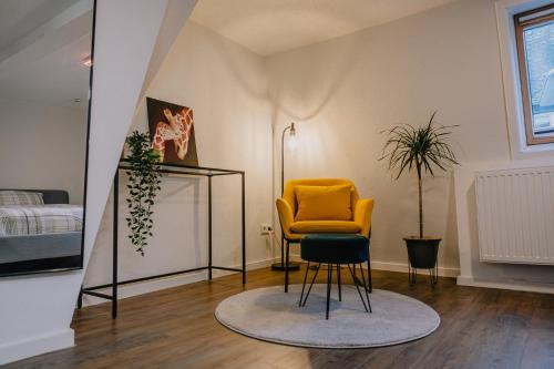 a living room with a yellow chair and a mirror at Gemütliches Haus mit 2 Zimmern in Vallendar