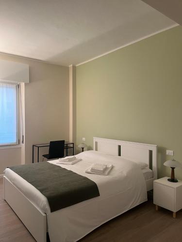 ein Schlafzimmer mit einem großen weißen Bett und einem Stuhl in der Unterkunft Tanny's Home in Verona