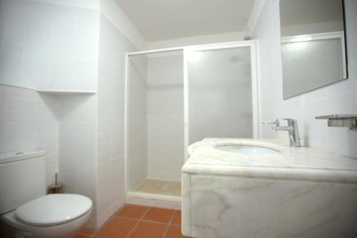 a white bathroom with a sink and a toilet at HI Évora – Pousada de Juventude in Évora