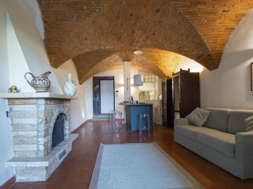 uma sala de estar com uma lareira de pedra e um sofá em Apartment Il Giardino di Lucia by Interhome em San Miniato