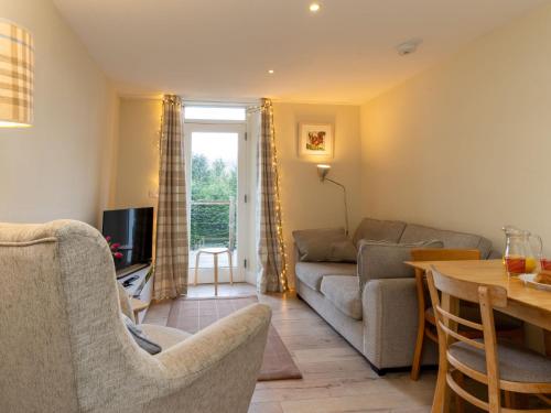 a living room with a couch and a table at Holiday Home 1 Railway Cottage by Interhome in Aviemore