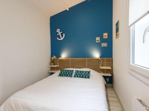 une chambre avec un lit avec un mur bleu dans l'établissement Holiday Home Les Trémières by Interhome, à La Palmyre