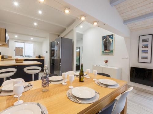 Un comedor y una cocina con mesa y sillas de madera. en Holiday Home Les Trémières by Interhome, en La Palmyre