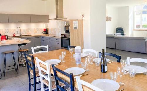 comedor con mesa y sillas y cocina en Gîte du Pavement, en Craon