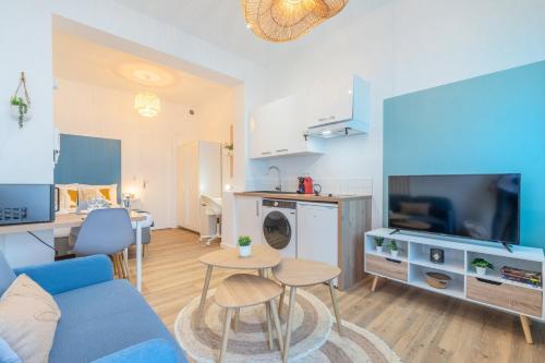 un salon avec un canapé bleu et une table dans l'établissement Studio near tram & Parc Barbieux, CHR + parking, à Roubaix
