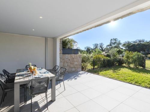 une salle à manger avec une table et des chaises sur un patio dans l'établissement Apartment Domaine d'Arca G1 by Interhome, à Porto-Vecchio