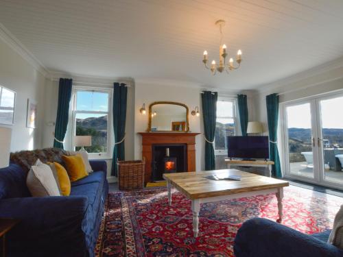 sala de estar con sofá azul y mesa en Holiday Home Achalic Farm House by Interhome, en Lerags