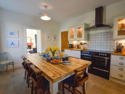 cocina con mesa de madera en Holiday Home Achalic Farm House by Interhome, en Lerags