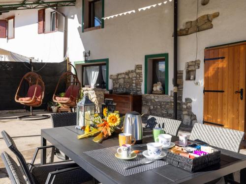 un tavolo con tazze e una composizione floreale sopra di Holiday Home Da Norma by Interhome a San Martino di Terzo